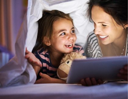 Mother and daughter sharing tablet device