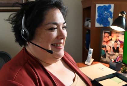 A customer service representative with a headset on is working from home.