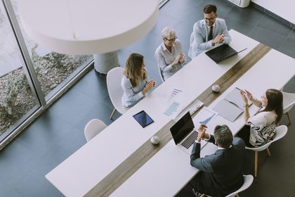 Group of people meeting in a conference room clapping