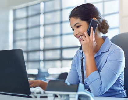 Woman on phone at her desk in an office environment.