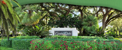 Green Oaks sign among abundant trees and shrubbery.
