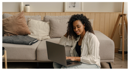Woman looking at laptop while sitting on the ground