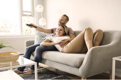 Couple laying on the couch watching TV
