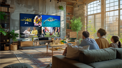 Group of people watching MultiView channels on TV in brightly lit loft space