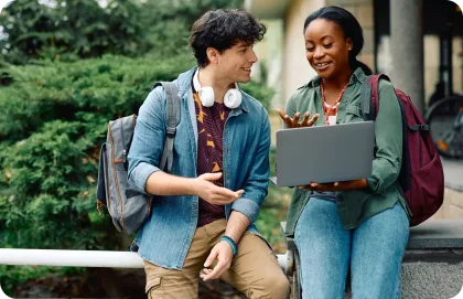 Man and woman looking at laptop outside