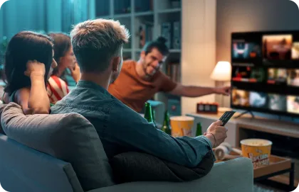 A group of friends watching TV together on a couch.