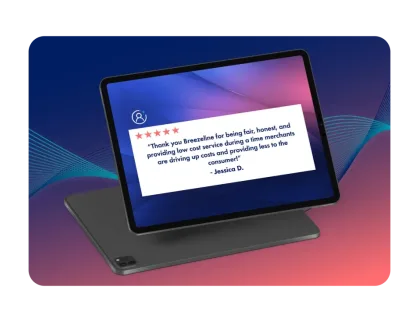 A tablet displaying a 5-star customer review from Jessica D. thanking Breezeline for fair, honest, and low-cost service.