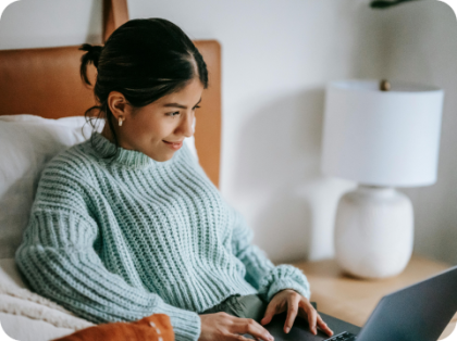 Woman sitting in bed with laptop